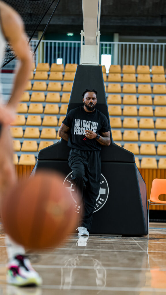 Portrait de Seidou appuyé contre un panier de Basket